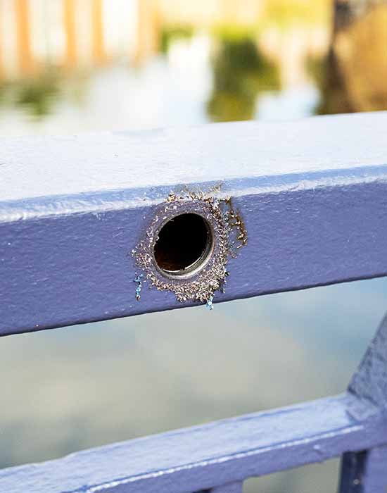 Retrofit handrail lighting a drilled hole in the face of a handrail painted blue